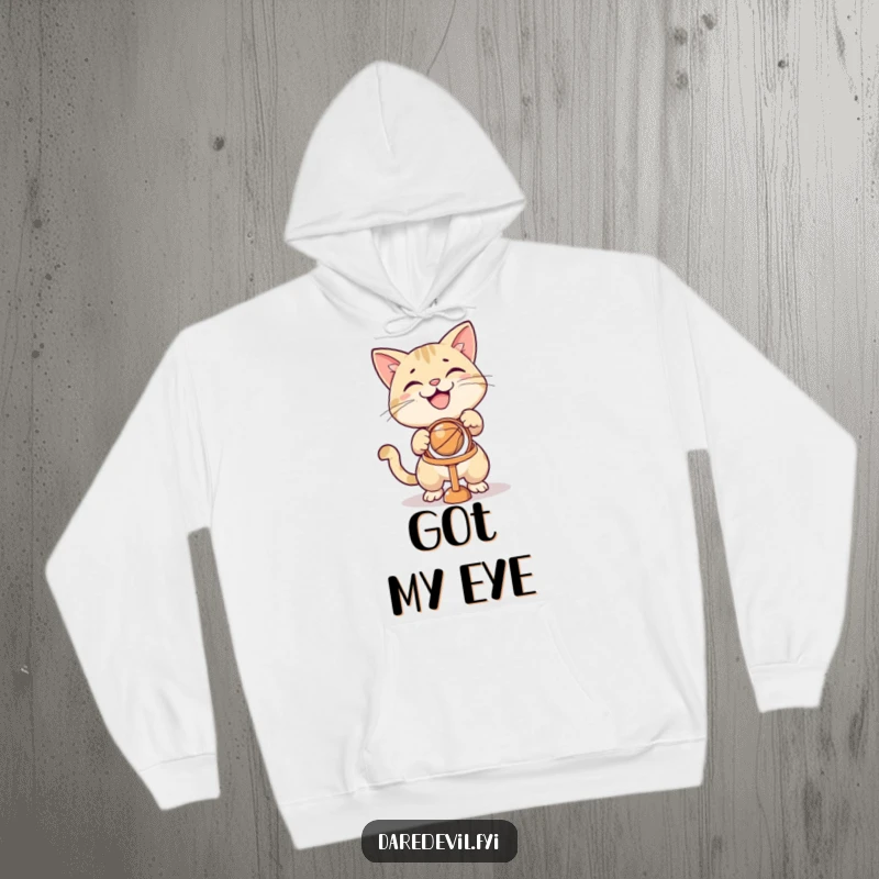 Funny grinning cat aiming a ball at a tiny hoop, featured on a soft, warm hoodie for cozy fun.