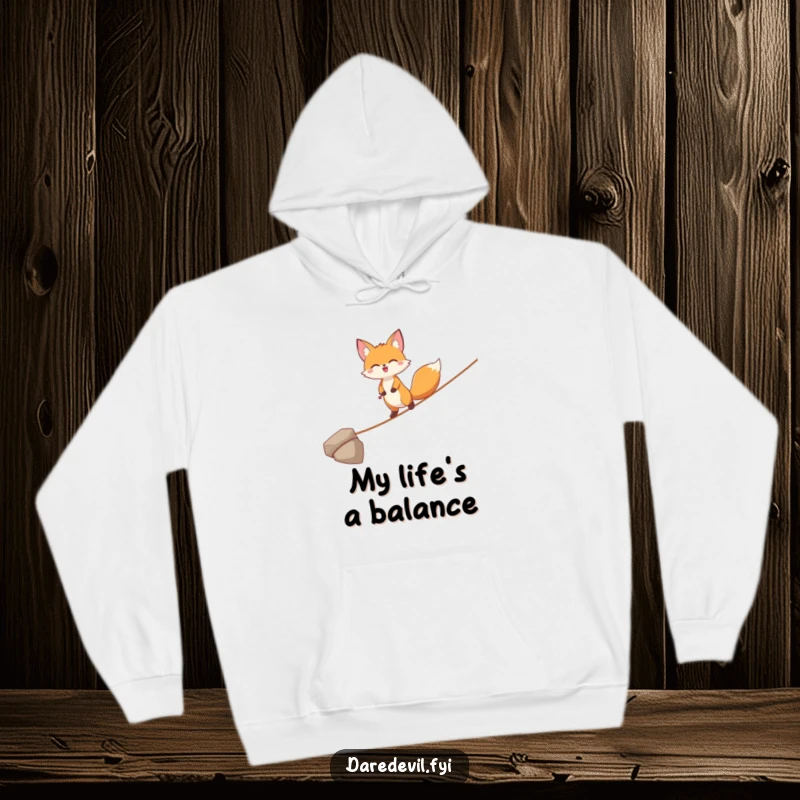Funny Fox Hoodie: A joyful fox character precariously balances on a thin tightrope, offering cozy comfort with a touch of daring style.