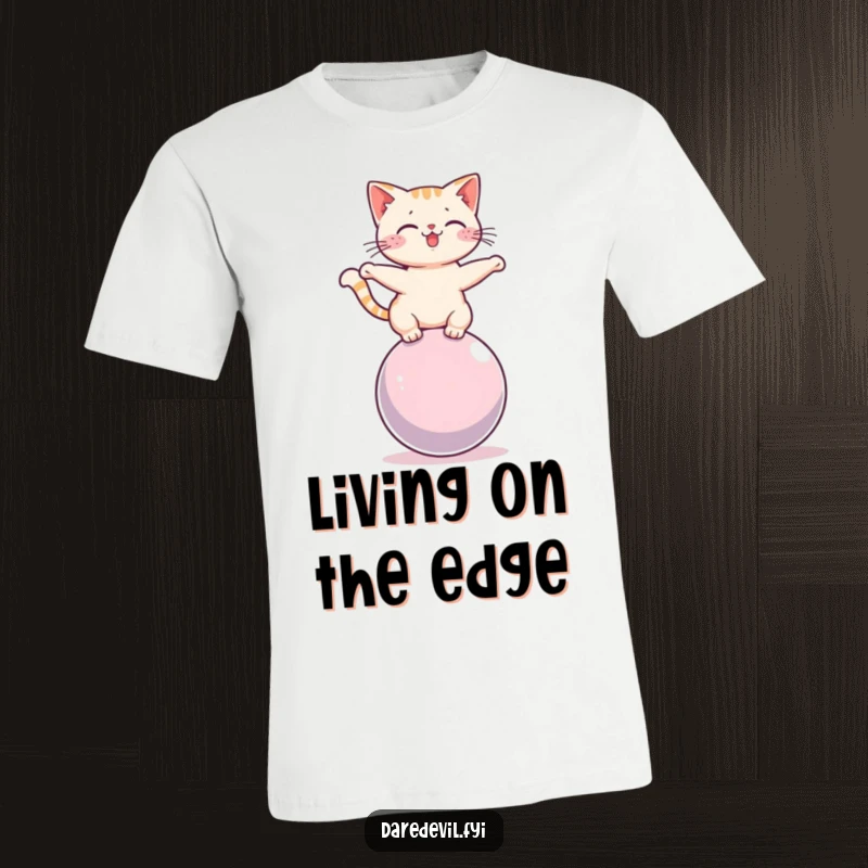 Funny cat in a precarious balancing act on a rolling sphere, printed on a comfortable, high-quality t-shirt.